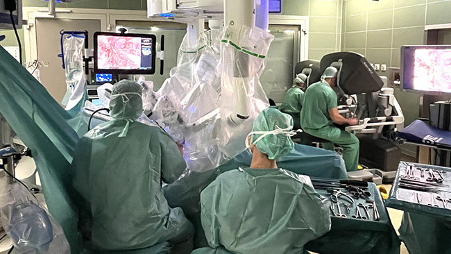 IM OP unterst�tzt das daVinci-System die Operateurinnen und Operateure, die an den beiden Steuerungskonsolen (im Bildhintergrund rechts) das System pr�zise steuern.