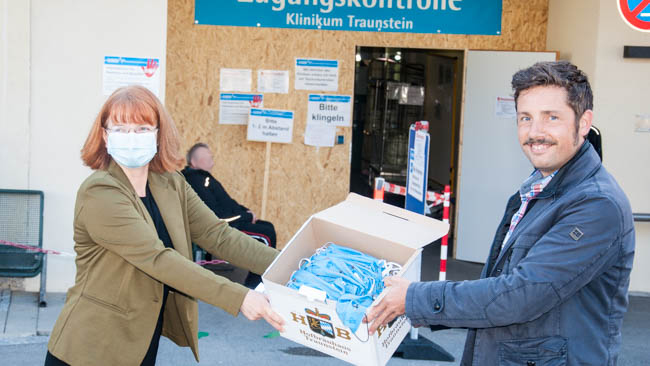 Maximilian Sailer vom Hofbräuhaus Traunstein übergibt die "Hofei-Masken" an Corinna Noack-Aetopulos, Fundraising und Drittmittelmanagement Kliniken Südostbayern AG