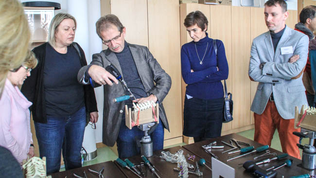 Prof. Dr. Rupert Ketterl (Mitte) demonstriert den Teilnehmern an einem Wirbelsäulenmodel die modernsten Operationstechniken, die sie anschließend selber üben konnten.